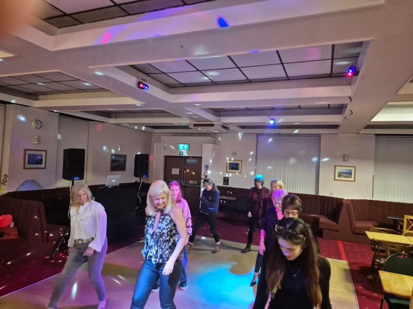 Dancers following a line dance routine at a group session