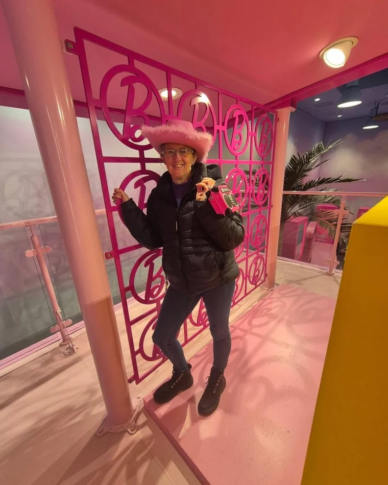 Anne in a pink hat enjoying a playful, brightly-themed photo spot
